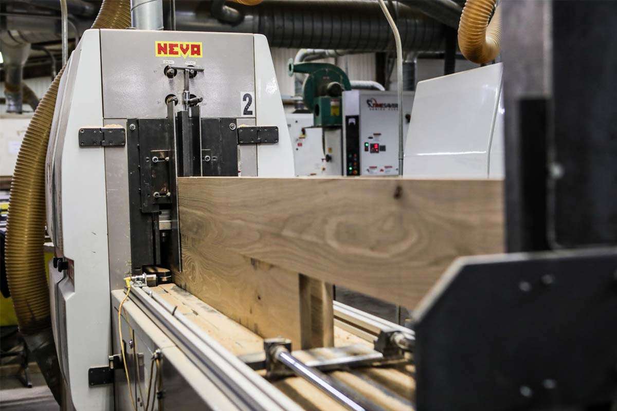 Machinery cutting boards into flooring